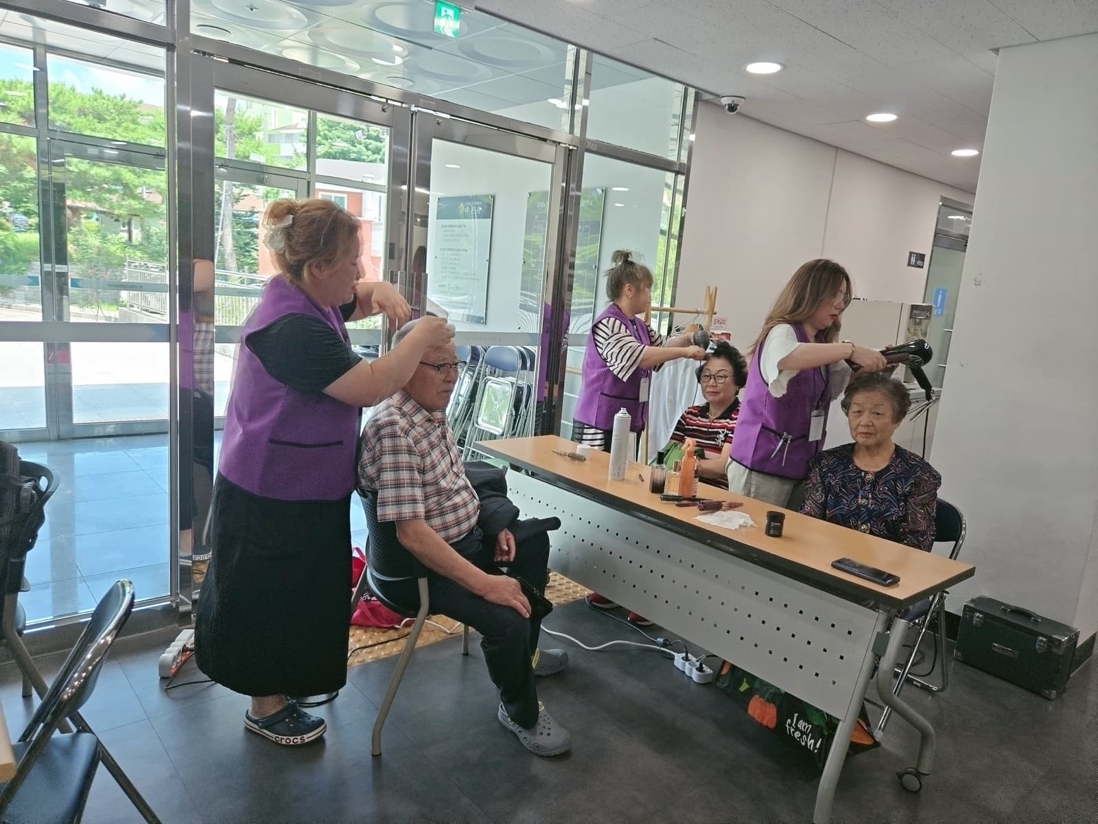 촬영 순서를 기다리는 어르신의 헤어를 다듬는 모습