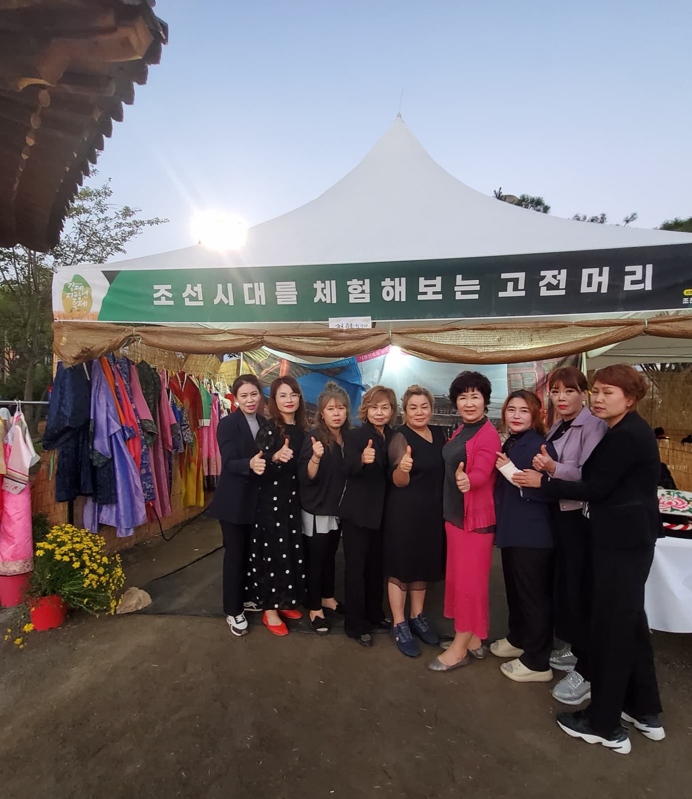 부스 앞에 선 회원들. 왼쪽에 체험용 한복을 크기별로 걸어 두었다