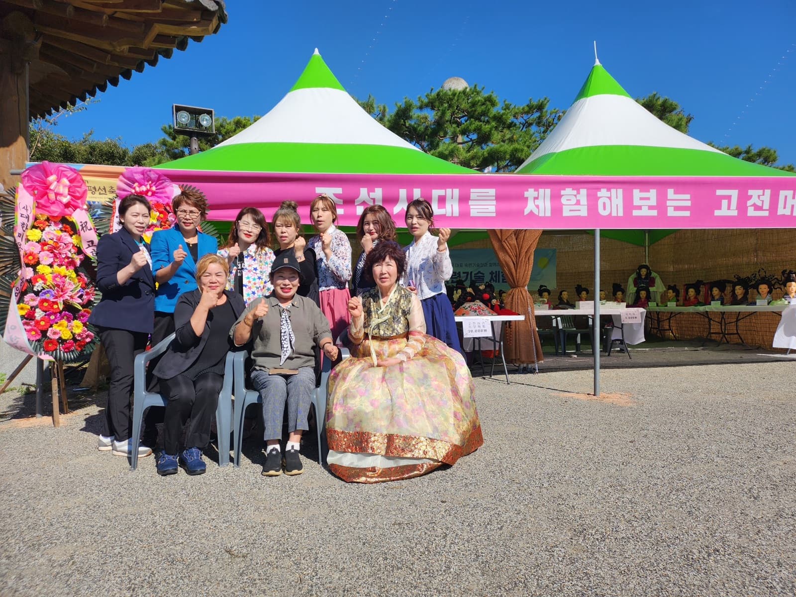부스 앞에 모인 회원들 — 왼쪽에 (사)대한미용사회 명의 축하 화환이 놓였다